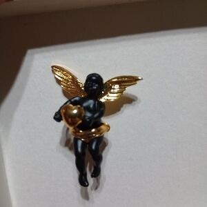 Angel brooch holding a gold heart